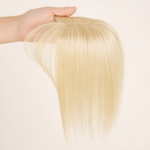 Hair Labs light blonde hair topper with bangs, the clip-in topper held in the hand, small base with bangs